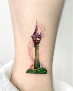 a woman's leg with a tattoo on it that has a tower in the middle