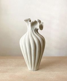 a white vase sitting on top of a table