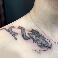 a woman's chest with two dragon tattoos on her chest and the letter h