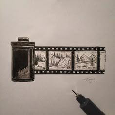 a hand holding a pen and drawing pictures on a white wall with film strips attached to it