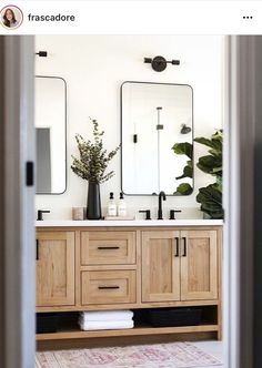 a bathroom with two mirrors and double sinks in it's center, along with a rug on the floor