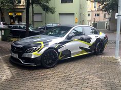 a black and yellow car is parked on the street