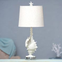 a white lamp sitting on top of a wooden table