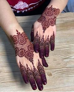 two hands with henna tattoos on them