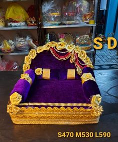 a purple and gold couch sitting on top of a table