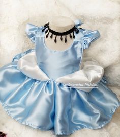 a blue and white dress sitting on top of a furnishing next to flowers