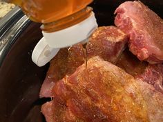 the meat is being poured into the slow cooker