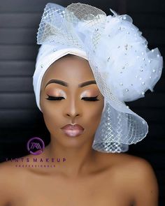 an african woman wearing a white turban with pearls on it's head