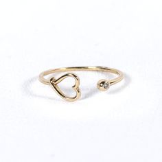 Experience unique charm with our Claw Ring with Heart. Crafted in 10K solid gold, this captivating ring features a delicate heart nestled within an intricately designed claw, adding a touch of edgy elegance and romance to your look. 10K Yellow Gold White Zirconia Adjustable Gold Rings With Heart Charm, Gold Rings With Heart Charm And Adjustable Fit, Adjustable Gold Ring With Heart Charm, Adjustable Open Heart Promise Jewelry, Tarnish-resistant Open Heart Promise Ring, Gold Adjustable Heart Cut Rings, Adjustable Gold Heart Cut Rings, Adjustable Heart-shaped Yellow Gold Midi Rings, Adjustable Yellow Gold Heart Midi Rings