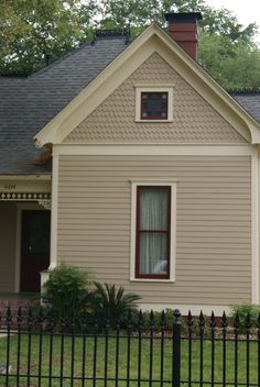 a small house with a black fence in front of it