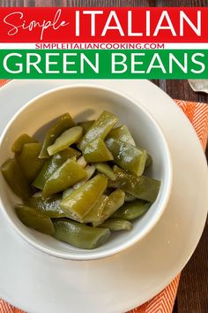 a white bowl filled with green beans sitting on top of a table next to an orange napkin