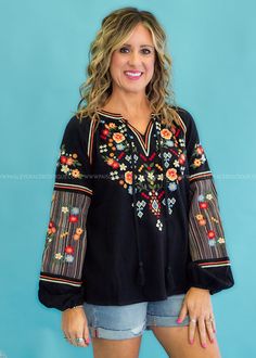 STARRY EYED FOR THIS EMBROIDERED CUTIE! Black with Multicolored Floral Embroidery Keyhole Neckline w/ Ties | Full-length Sleeves w/ Elastic Wrist | Split Hemline Woven | No Stretch | Fits True To Size Main: 100% Contrast: 50% Cotton 50% Polyester Measurements Bust Measured Laid Flat Across Front | Armpit to Armpit S 20” | M 21” | L 22” | 1XL 25” | 2XL 26” | 3XL 17” Length Measured Shoulder to Hemline S 25” | M 26” | L 26” | 1XL 27” | 2XL 28” | 3XL 28” Model: Holly is wearing a Small, Carolyn is Folk Style Embroidered Peasant Top, Black Embroidered Cotton Peasant Top, Folk Style V-neck Top With Intricate Embroidery, Black Embroidered Folk Peasant Top, Folk Style Embroidered V-neck Tops, Western Dress, Starry Eyed, Keyhole Neckline, Stars Hollow