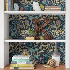 two bookshelves with decorative wallpaper on them, one is white and the other is blue