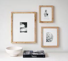 three framed photographs hang on the wall next to a bowl and black and white photograph