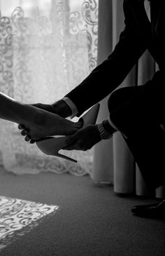 a man and woman are holding scissors in their hands while sitting on the floor with curtains behind them