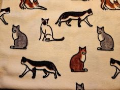 a towel with cats on it sitting next to each other