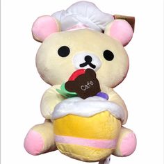 a teddy bear holding a cupcake in its paws and wearing a chef's hat