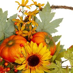 an arrangement of pumpkins, sunflowers and leaves