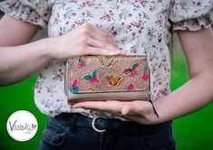 a woman is holding a purse with butterflies on it and her hands are in the pocket