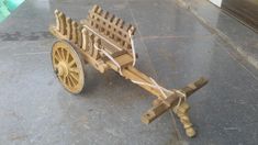 an old wooden cart is sitting on the ground with rope attached to it's wheels