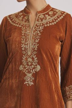 Brown velvet kurta with floral embroidered yoke and sleeve hem. Comes with contrast embroidered hem pyjama. Components: 2 Pattern: Embroidered Type Of Work: Floral Neckline: Notched Band Sleeve Type: Three Quarter Fabric: Velvet Color: Brown Other Details:  Triangular lace hem Model height: 5ft 11inches, wearing size M Occasion: Mehendi and Haldi - Aza Fashions Pret Wear, Velvet Kurta, Latest Bridal Lehenga, Lehnga Dress, Embroidered Hem, Designer Kurti Patterns