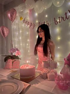 a woman standing in front of a birthday cake