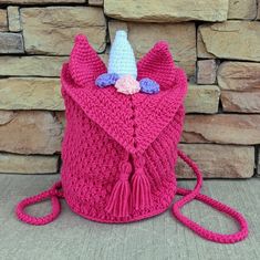 a pink crocheted bag with a unicorn horn on it