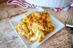 a white plate topped with macaroni and cheese on top of a wooden table