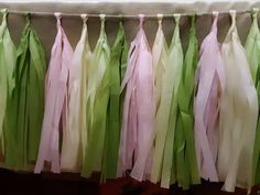 green and pink tissue tassels hanging from a line