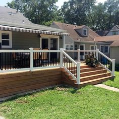 a house with a deck and railing in the front yard