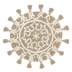 a round rug with tassels on the sides and an ornate design in white