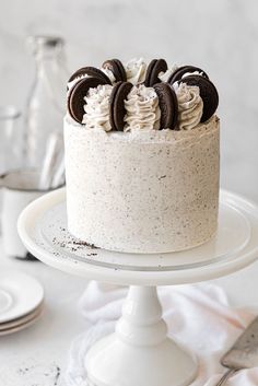 an oreo cookies and cream cake on a white plate with silverware next to it