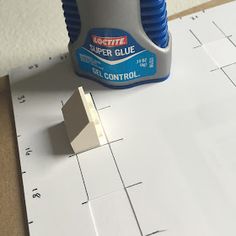 a glue dispenser sitting on top of construction paper