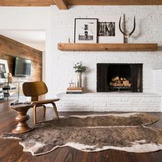 a living room with a white brick fireplace and wood flooring in front of it