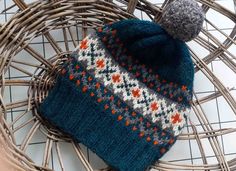 a knitted hat sitting on top of a wicker basket