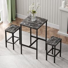 three tables and two stools with flowers in vase on carpeted floor next to fireplace