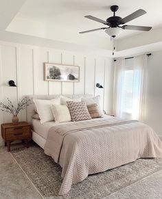 a bedroom with a bed, dresser and ceiling fan