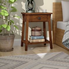 a small wooden table with some books on it and a potted plant next to it