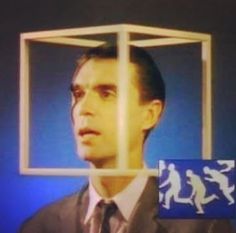 a man in a suit and tie is looking at something through a caged window