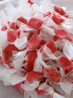 red and white candies are sitting on top of each other in plastic wrappers