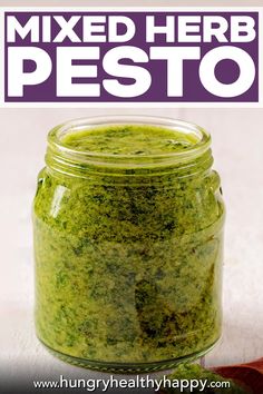 a jar filled with pesto next to a spoon