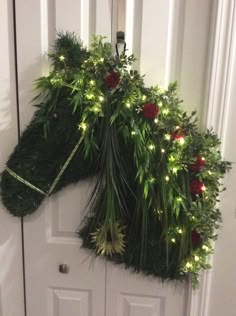 a door decorated with christmas greenery and lights