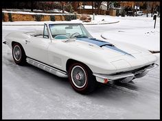 an old white car parked in the snow