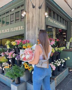 a woman standing in front of a flower shop