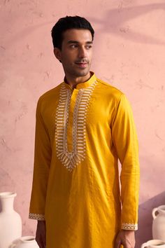 SHRESTHA BY VASTRAMAY Men's Yellow Silk Machine Embroidered Kurta Luxuriate in this vibrant yellow kurta, featuring intricate machine embroidery. Made from a silk blend, this kurta boasts a comfortable and stylish fit. Pair it with a dhoti or pajamas for a complete traditional look. Key Features Yellow silk blend with machine embroidery Mandarin collar Long sleeves Side slits Pockets Specifications Sleeve Length: Full Sleeves Top Shape: Straight Top Hemline: Straight Top Length: Knee Length Mate Traditional Yellow Sherwani Straight Kurta, Designer Yellow Slub Silk Kurta, Yellow Bandhgala With Resham Embroidery Straight Kurta, Unstitched Yellow Slub Silk Kurta, Yellow Semi-stitched Slub Silk Kurta, Full Sleeve Top, Pajama Pant, Sleeveless Jacket, Mandarin Collar