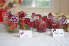 there are many small cups with fruits and veggies in them on the table