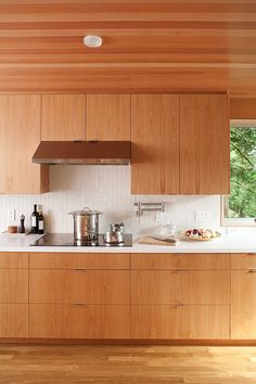 a kitchen with wooden cabinets and stainless steel appliances in the center, along with white counter tops