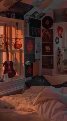 a bed room with a guitar hanging from the ceiling and a window in front of it