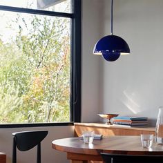 a dining room table with two chairs next to it and a lamp hanging from the ceiling