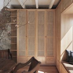 a room with a wooden table and chair next to a book shelf filled with books